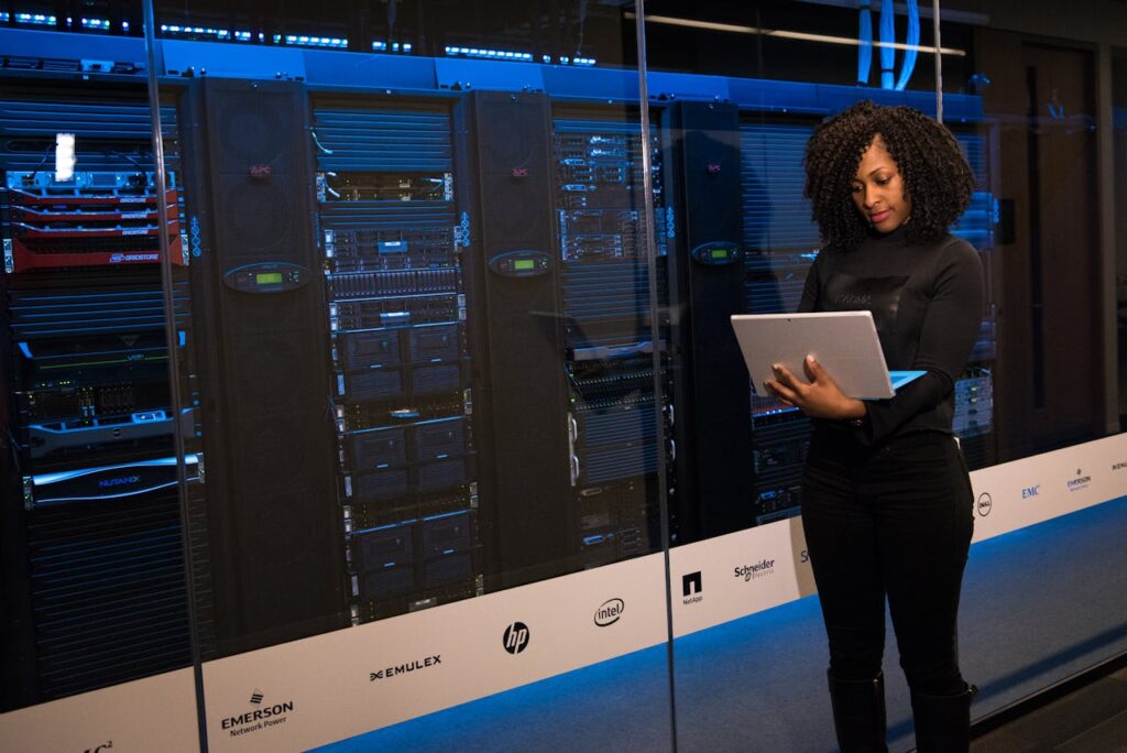 zipwp-image-1181354 Software Engineer Standing Beside Server Racks